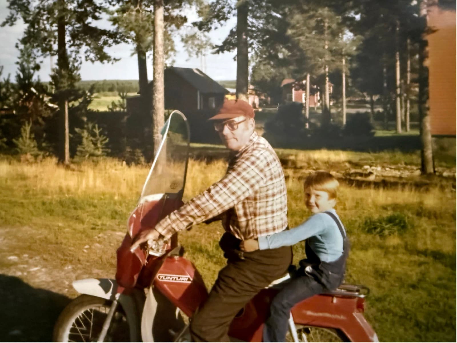 A man and a child on an old moped